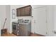 Laundry room with wooden floors, front-loading washer/dryer, and upper cabinets at 2104 Leatherbridge Ct, North Las Vegas, NV 89081