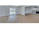 Spacious living room with modern flooring, sliding door to backyard, and bright white brick fireplace at 212 View Dr, Las Vegas, NV 89107