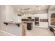 Modern kitchen with white cabinets, stainless steel appliances, and breakfast bar seating at 2143 Vista Famosa Ct, Las Vegas, NV 89123