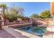Inviting pool area with a waterfall feature, mature landscaping, and ample space for relaxation and outdoor gatherings at 2143 Vista Famosa Ct, Las Vegas, NV 89123