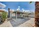 Exterior view of a backyard with covered patio, gravel, and a block wall at 2377 Los Feliz St, Las Vegas, NV 89156
