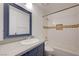 This bathroom has a single sink vanity, tile accents, and bathtub with shower at 2377 Los Feliz St, Las Vegas, NV 89156