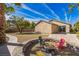 The backyard features a putting green, fire pit with chairs, mature landscaping, and clear blue skies at 250 Aspen Bay Ln, Henderson, NV 89012
