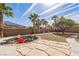 Expansive backyard with a putting green, fire pit with chairs, mature landscaping, and clear blue skies at 250 Aspen Bay Ln, Henderson, NV 89012