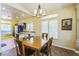 Sunlit dining area with wood-look floors adjacent to an open kitchen with breakfast bar at 250 Aspen Bay Ln, Henderson, NV 89012