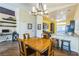 Bright dining area features wood floors, modern lighting fixture, and breakfast bar overlooking the kitchen at 250 Aspen Bay Ln, Henderson, NV 89012