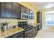 Stylish kitchen showcasing dark cabinetry, granite countertops, and stainless steel appliances at 250 Aspen Bay Ln, Henderson, NV 89012