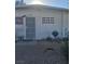 Exterior view of a house featuring a white block wall, barred windows and door, and xeriscaping at 2888 El Cajon St, Las Vegas, NV 89169
