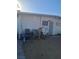 Exterior view of a house featuring a white block wall, barred windows and door, and unkempt yard at 2888 El Cajon St, Las Vegas, NV 89169