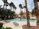 Community pool surrounded by palm trees and lounge chairs, perfect for relaxing and enjoying the weather at 2925 Wigwam Pkwy # 724, Henderson, NV 89074