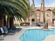 Inviting community pool area with lounge chairs and palm trees, ideal for leisure and relaxation at 2925 Wigwam Pkwy # 724, Henderson, NV 89074
