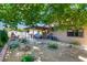 Landscaped backyard with a covered patio, seating area, and mature trees at 3138 Valleywood Rd, Henderson, NV 89014