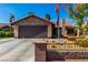 Charming single-story home featuring stone accents, a two-car garage, and low-maintenance desert landscaping at 3138 Valleywood Rd, Henderson, NV 89014