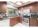 Spacious kitchen featuring stainless steel appliances, white tile floors, and a window overlooking the backyard at 3138 Valleywood Rd, Henderson, NV 89014