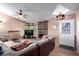 Cozy living room with a stone fireplace, neutral paint, a ceiling fan, and access to the front door at 3138 Valleywood Rd, Henderson, NV 89014