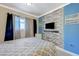 Modern bedroom featuring a blue accent wall, flat-screen TV, comfortable bed, and natural light from the window at 3266 Mountain Spring Rd, Las Vegas, NV 89146
