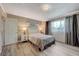 Bedroom features a chandelier light fixture, a picture window, an ensuite, and light grey laminate flooring at 3266 Mountain Spring Rd, Las Vegas, NV 89146
