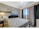 Comfortable bedroom with a sleek desk, shelving, a queen bed, and curtains that block sunlight at 3266 Mountain Spring Rd, Las Vegas, NV 89146