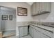 Close-up of a kitchenette with grey cabinets, tile flooring, and granite countertop at 3266 Mountain Spring Rd, Las Vegas, NV 89146