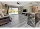 Bright living room featuring wood floors, ceiling fan, and sliding glass doors to the pool at 3266 Mountain Spring Rd, Las Vegas, NV 89146