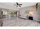 Open living room showcases an eat-in kitchen, modern ceiling fan, grey toned walls, and light gray laminate flooring at 3266 Mountain Spring Rd, Las Vegas, NV 89146