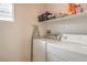 Laundry area featuring modern washer and dryer units, a shelf, and a bright window at 3568 Gloucester Gate St, Las Vegas, NV 89122