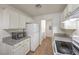 Kitchen with granite counters, white cabinets and appliances, and wood-look flooring at 3660 Renovah St # 202, Las Vegas, NV 89129