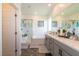 Modern bathroom featuring a double sink vanity with gray cabinets and glass-enclosed shower and bath at 3817 Grazing Gazelle Ave, North Las Vegas, NV 89084
