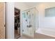 Bright bathroom features a glass shower and soaking tub with storage and an adjacent walk-in closet at 3817 Grazing Gazelle Ave, North Las Vegas, NV 89084