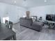 Open-concept living room with modern gray sofa, contemporary decor, and light gray flooring at 3934 Palos Verdes St, Las Vegas, NV 89119