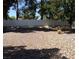 View of an empty backyard with a gray block wall and desert landscaping with mature trees at 3948 Applecrest St, Las Vegas, NV 89108