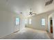 Sun-lit living room featuring a ceiling fan, multiple windows, and access door to backyard at 4330 Turner Blvd, Pahrump, NV 89061
