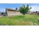 Spacious backyard featuring green lawn, a small tree, and a covered patio at 4428 Ash Ave, Las Vegas, NV 89110
