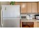 Galley kitchen showcasing a white refrigerator, light wood cabinets, and laminate countertops at 4428 Ash Ave, Las Vegas, NV 89110