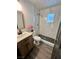 Updated bathroom with white marble tile shower, wood vanity, and stylish modern finishes at 5013 Vermont Ave, Las Vegas, NV 89107