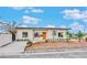 Inviting single-story home with an orange front door, easy care landscape, and fresh exterior paint at 5013 Vermont Ave, Las Vegas, NV 89107