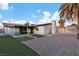 Spacious backyard with synthetic grass, a gravel area, a patio, and palm trees at 5208 Overland Ave, Las Vegas, NV 89107