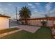 A backyard showcases a lawn area, desert landscaping, a wooden fence and mature trees at 5208 Overland Ave, Las Vegas, NV 89107