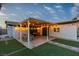 This outdoor patio includes string lights, seating and a foosball table perfect for entertaining at 5208 Overland Ave, Las Vegas, NV 89107