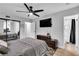 Bedroom featuring a ceiling fan, TV, mirrored closet and ensuite bathroom at 5208 Overland Ave, Las Vegas, NV 89107