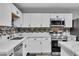 Bright kitchen features stainless appliances, white cabinetry, and decorative backsplash at 5208 Overland Ave, Las Vegas, NV 89107