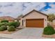 Inviting home featuring a two-car garage, desert landscaping, and warm color scheme at 5319 Farley Feather Ct, North Las Vegas, NV 89031