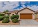 Charming single-story home with a desert landscape and a two-car brown garage door at 5319 Farley Feather Ct, North Las Vegas, NV 89031