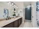Bathroom featuring double sinks with granite counters and elegant fixtures and a decorative shower curtain at 5853 Gentleslope St, Henderson, NV 89011
