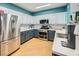 Modern kitchen featuring stainless steel appliances, updated countertops, and stylish blue and white cabinetry at 5853 Gentleslope St, Henderson, NV 89011