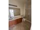 Bright bathroom features a single vanity, framed mirror, tile flooring, and a glass door shower at 6158 Calm Breeze Ave # 101, Las Vegas, NV 89108