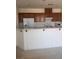 Kitchen area featuring a breakfast bar, white appliances, and wooden cabinets at 6158 Calm Breeze Ave # 101, Las Vegas, NV 89108
