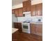 Kitchen with wooden cabinets, white appliances, and a view of the wood-style flooring at 6158 Calm Breeze Ave # 101, Las Vegas, NV 89108