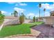 Expansive backyard featuring manicured lawn, mature trees, a brick patio, and white privacy fencing at 6408 Shawnee Pl, Las Vegas, NV 89107