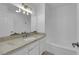 Bright bathroom featuring a vanity with granite countertop, modern light fixture and a shower tub at 6408 Shawnee Pl, Las Vegas, NV 89107
